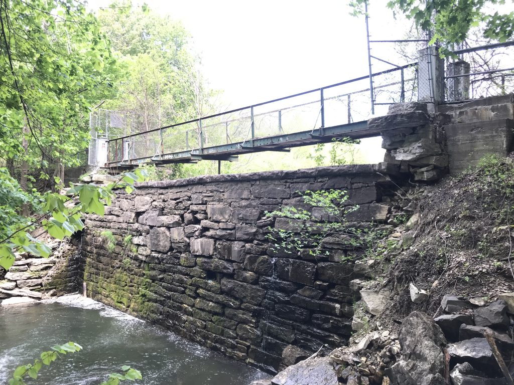 photo 13 View of pedestrian bridge and water seepage on the downstream face of the dam